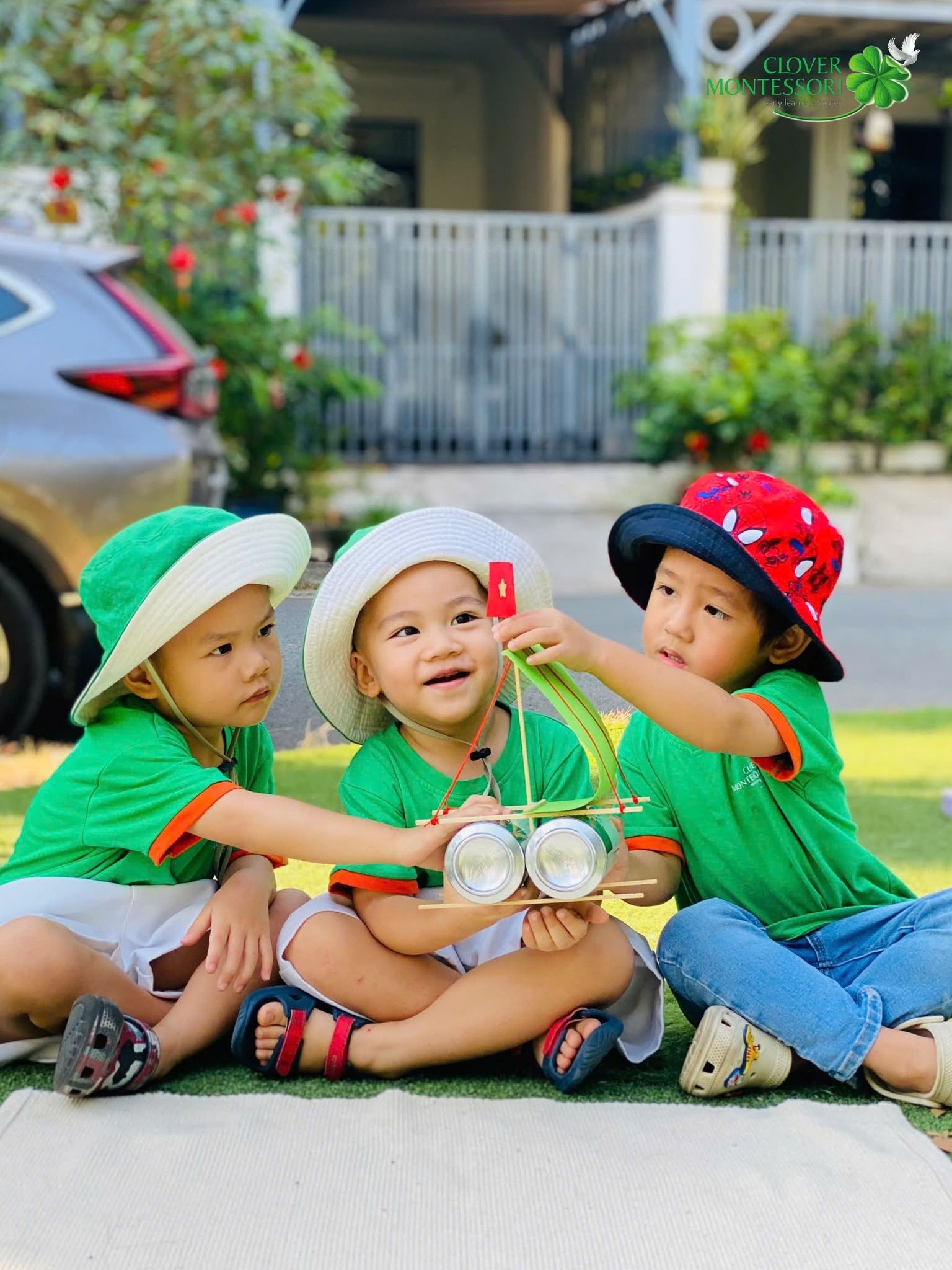 Các bé ngồi chơi cùng nhau ngoài sân trường