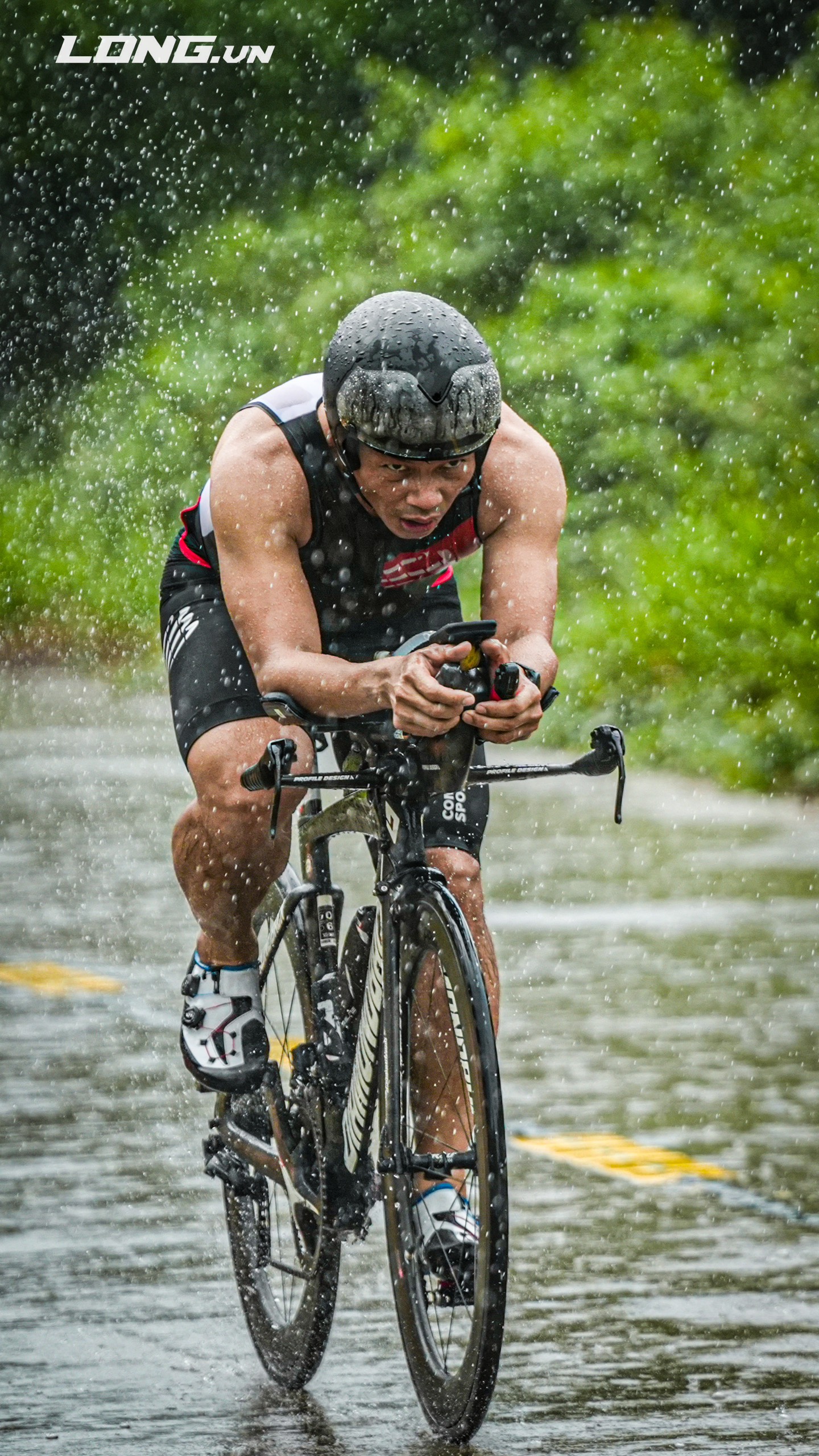 Thầy Phạm Thành Long đạp xe dưới mưa trên đường đua triathlon