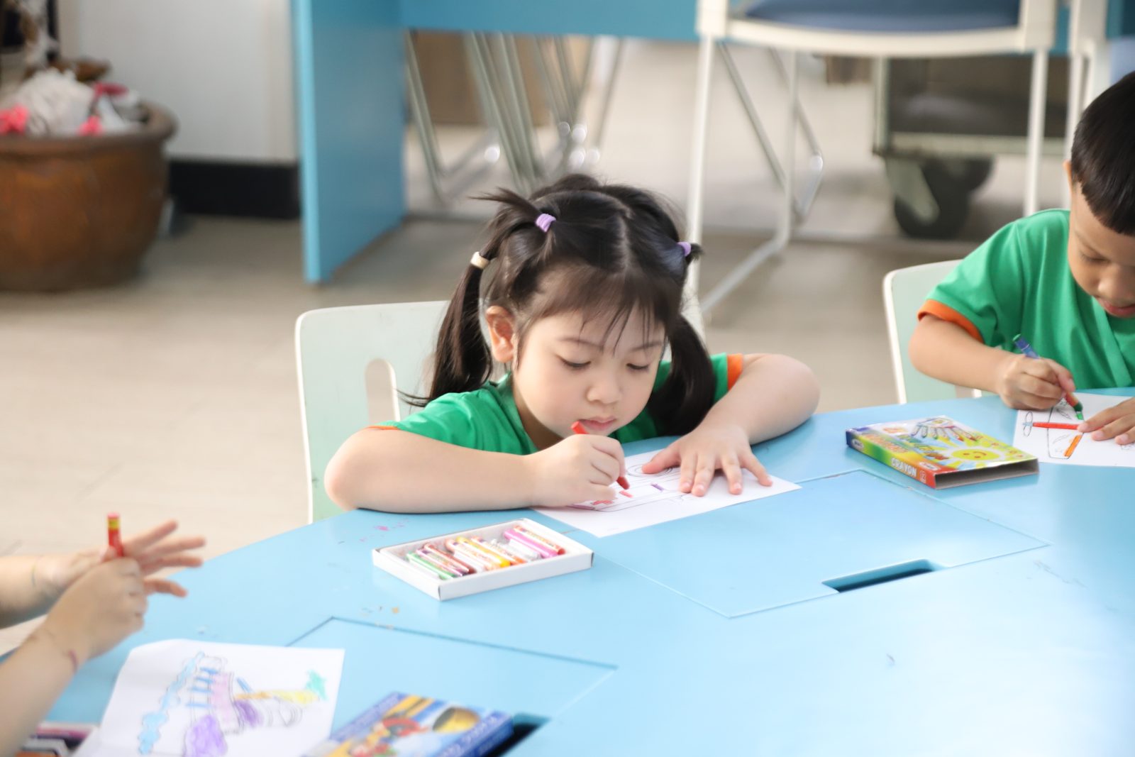 Bé tập trung cầm bút tô màu, rèn cơ tay trước khi vào lớp 1